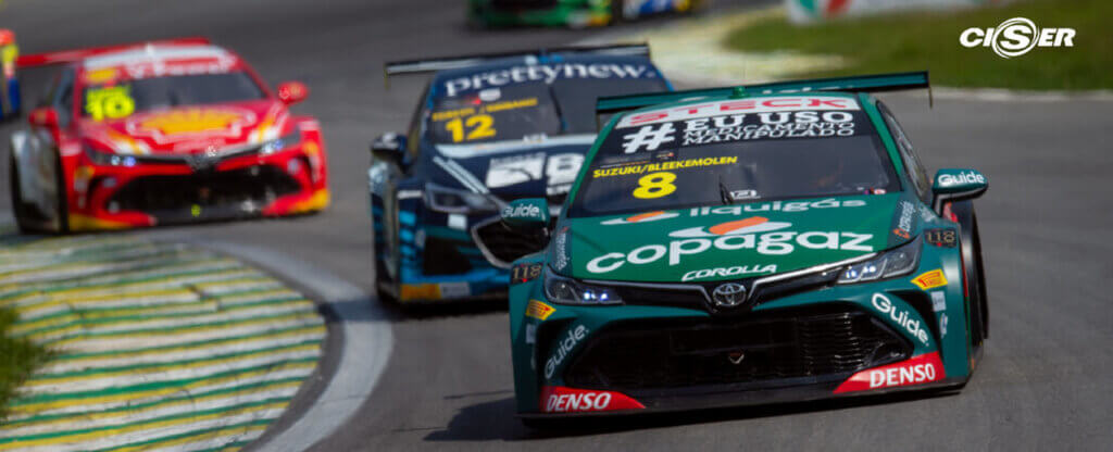 Carros verde e vermelho na pista em movimento durante a Copa Truck