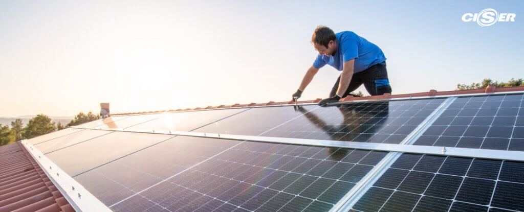 Técnico instala painel solar como característica de construção sustentável.